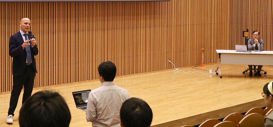 会場やオンライン視聴者の質問に答えるリスト特任教授（左端）と、司会の寳金清博北海道大学総長（右端）